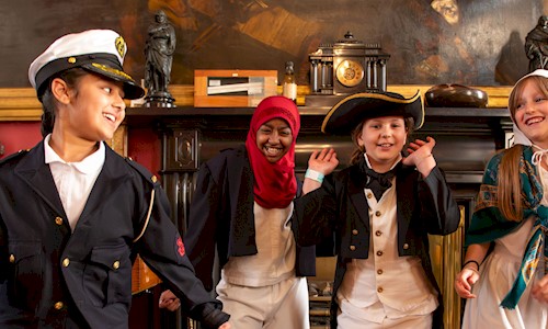 Four young people dressed up dancing and big smiles on their faces