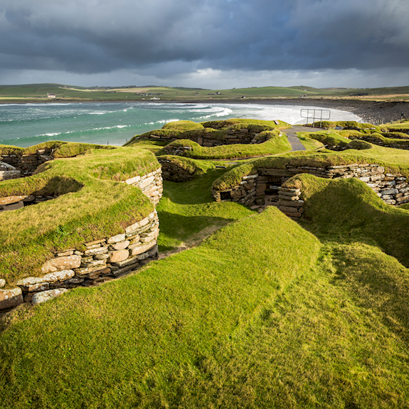 view out over the prehistoric village of Skara Brae with the sea in the background