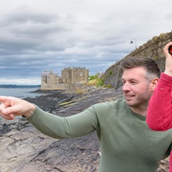 Visitors on the shore at Blackness using binoculars to enjoy the view, blackness castle in the background