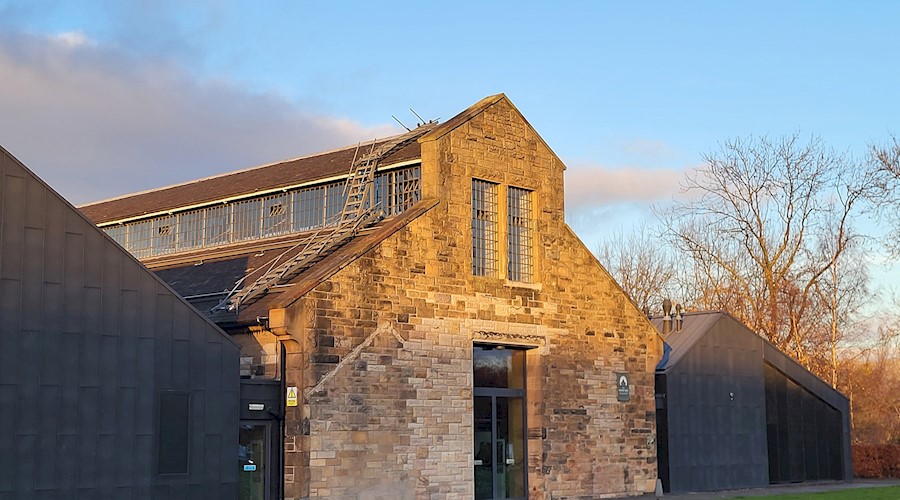 The Engine Shed building - a traditional blonde sandstone building with two modern black wings flanking the original building