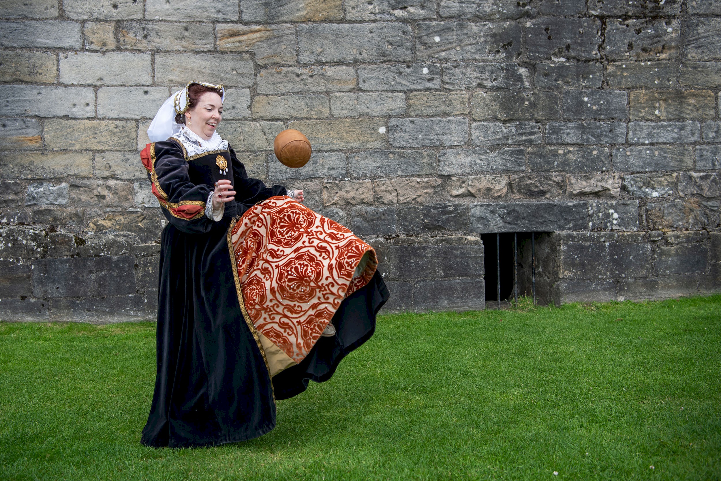 A woman in period costume doing keepy-uppies