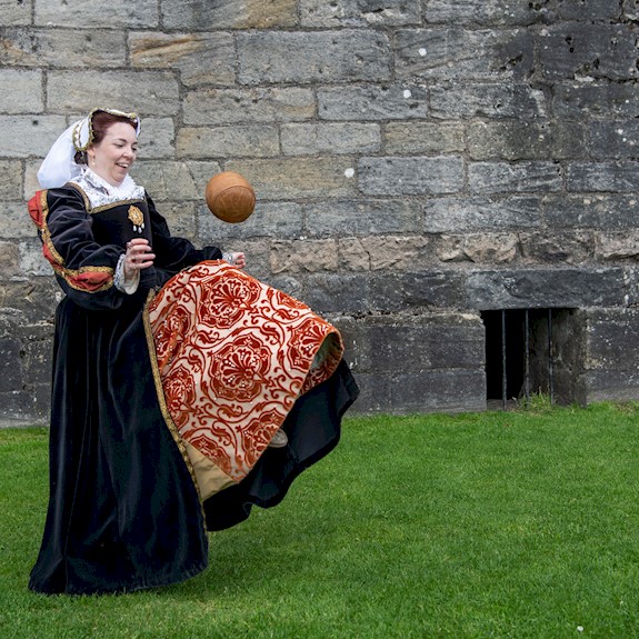 A woman in period costume doing keepy-uppies