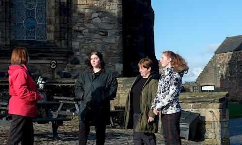 An Edinburgh Castle guide talking to women on a tour