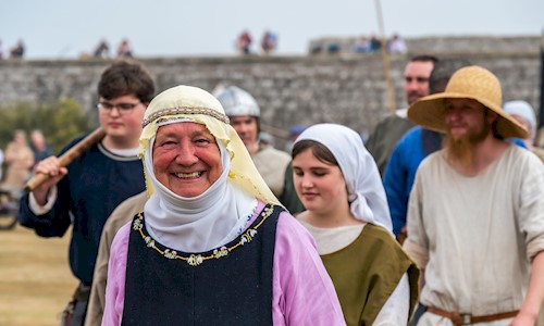 Costumed performers in castle grounds smiling for the camera