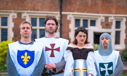 Four people in historical costume for different 'teams' standing in a line looking nonplussed